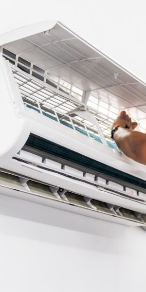 Young repairman fixing a ductless minisplit air conditioning system